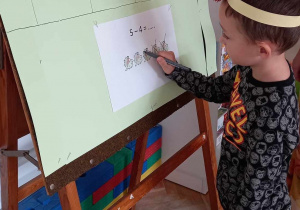 Chłopiec rozwiązuje matematyczne zadanie.