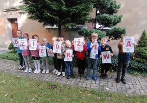 Dzieci trzymają napis "Dzień drzewa".