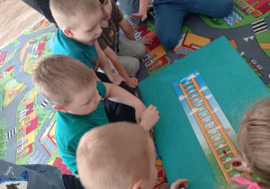 Dzieci grają w grę planszową pt. "Drabina".