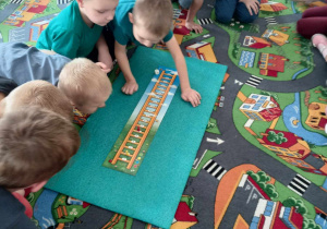 Dzieci grają w grę planszową pt. "Drabina".