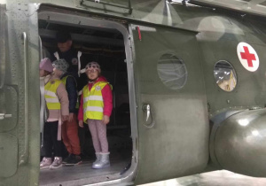 Dzieci oglądają wnętrze helikoptera.
