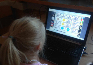 Dziewczynka gra na komputerze w memory.