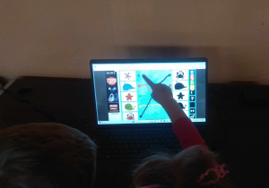 Dzieci grają w grę edukacyjną, w której łączą kropki obrazka z właściwym cieniem.