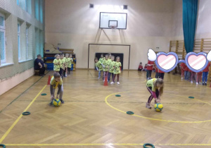 Dzieci uczestniczą w konkurencjach sportowych z piłką.