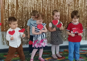 Dzieci prezentują piosenkę z serduszkami.