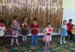 Dzieci prezentują piosenkę z serduszkami.