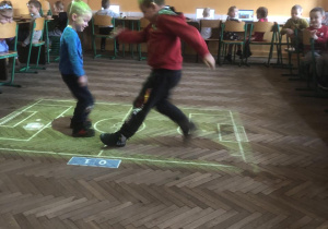 Dzieci grają w piłkę na magicznym dywanie.