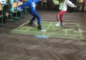 Dzieci grają w piłkę na magicznym dywanie.
