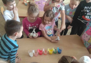 Dzieci obserwują wędrujące kolory z kubka do kubka.