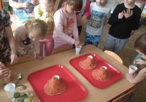 Dzieci mieszają składniki do lawy wulkanicznej: wodę, sodę oczyszczoną, płyn do mycia naczyń, barwnik spożywczy..