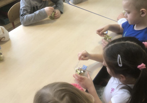 Dzieci degustują sałatkę grecką.