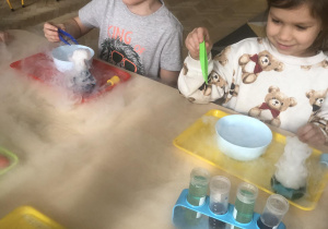 Dzieci wykonują eksperymenty z suchym lodem.
