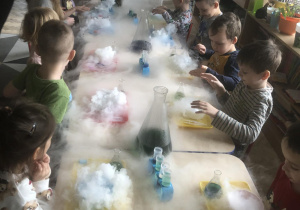 Dzieci wykonują eksperymenty z suchym lodem.