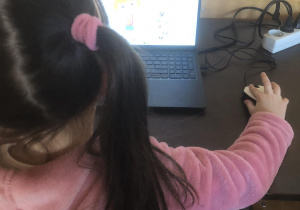 Dziewczynka uczy się obsługi komputera.