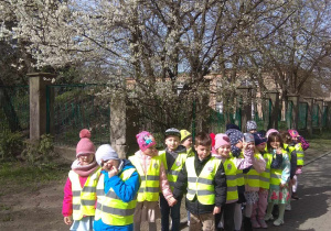 Dzieci idą na spacer w poszukiwaniu wiosny. Pierwsza oznaka znaleziona - kwitnące drzewo.