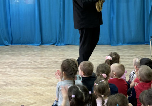 Dzieci słuchają utworu wykonywanego na instrumencie dętym.