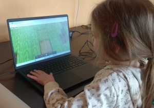 Dziewczynka gra w grę Minecraft.