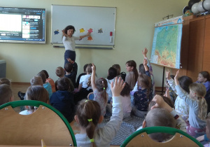 Dzieci podczas lekcji angielskiego, nazywają wskazany przez nauczyciela kolor.