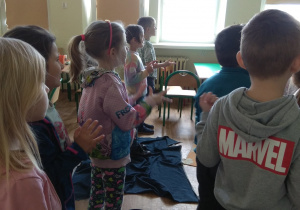 Dzieci bawia się podczas lekcji angielskiego, wskazują na palcach podaną cyfrę.