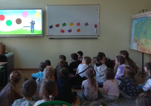 Dzieci słuchają i śpiewają piosenkę o kolorach.