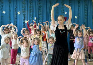 Tancerka uczy dzieci kroków poloneza.
