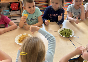 Dzieci próbują nachosów z guacamole.