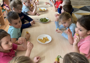 Dzieci próbują nachosów z guacamole.