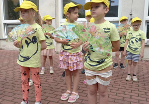 Dzieci prezentują na scenie japoński taniec z wachlarzami.