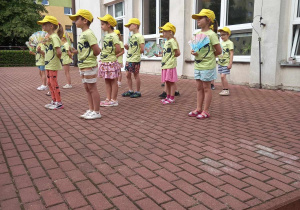 Dzieci prezentują na scenie japoński taniec z wachlarzami.