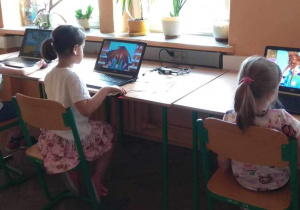 Dzieci grają na komputerach w gry edukacyjne.