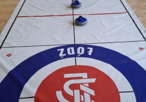 Dzieci grają w curling.