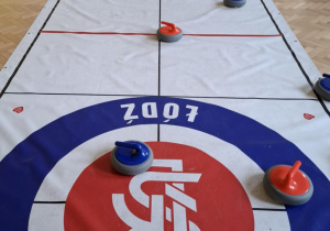 Dzieci grają w curling.