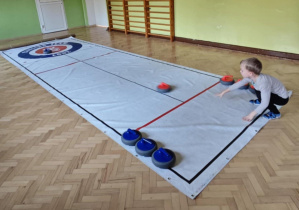 Dzieci grają w curling.