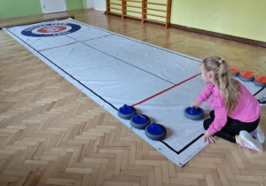 Dzieci grają w curling.