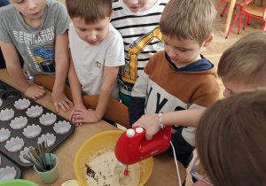 Dzieci za pomocą miksera łączą kolejno składniki.