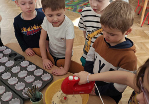 Dzieci za pomocą miksera łączą kolejno składniki.