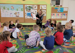 Mama Gabrysi czyta dzieciom książkę.