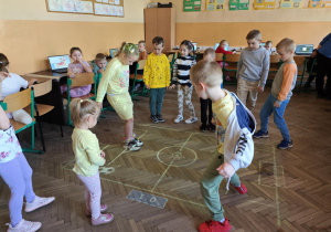 Na podłodze dzieci rozgrywają wirtualny mecz w piłkę nożną.