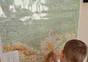 Dziecko wskazuje Kraków na mapie Polski.