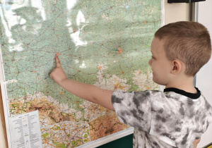 Dziecko wskazuje Poznań na mapie Polski.