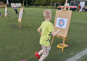 Dzieci z grupy zielonej w trakcie wykonywania konkurencji sportowych.