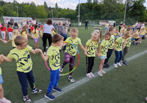 Dzieci z grupy zielonej w trakcie wykonywania konkurencji sportowych.