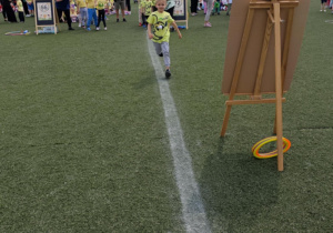 Dzieci z grupy zielonej w trakcie wykonywania konkurencji sportowych.