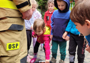 Dzieci korzystają ze sprzętu strażackiego.