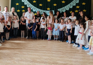 Rodzice stoją przy swoich dzieciach.