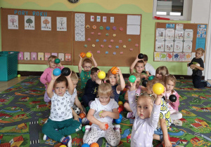 Dzieci wykonują rytmiczne ćwiczenia z piłkami przy muzyce klasycznej.