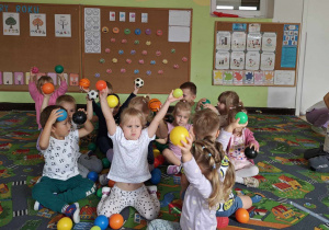 Dzieci wykonują rytmiczne ćwiczenia z piłkami przy muzyce klasycznej.