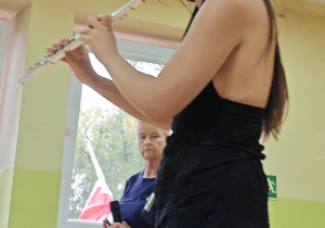 Artystka gra na flecie poprzecznym blaszanym.