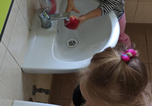 Dzieci myją jabłka.
