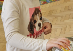 Dziewczynka dodaje kukurydzę do sałatki.